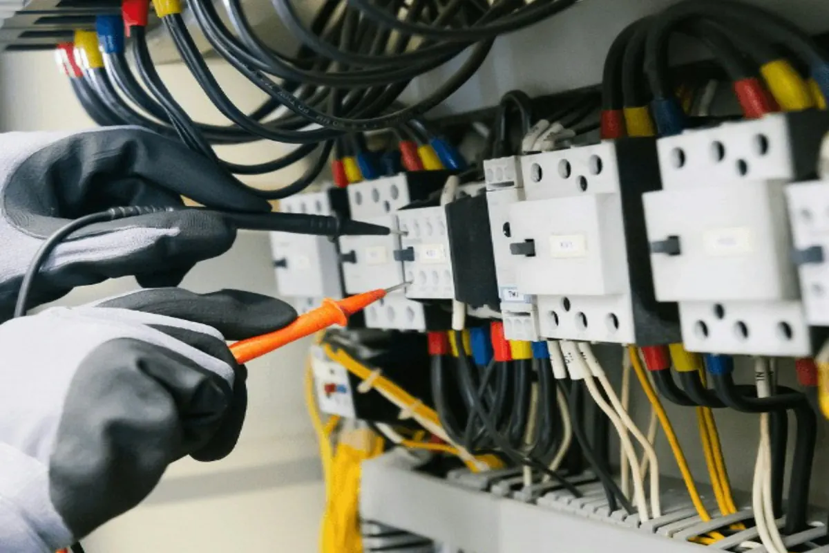 Técnico midiendo con un tester los contactos de un tablero eléctrico